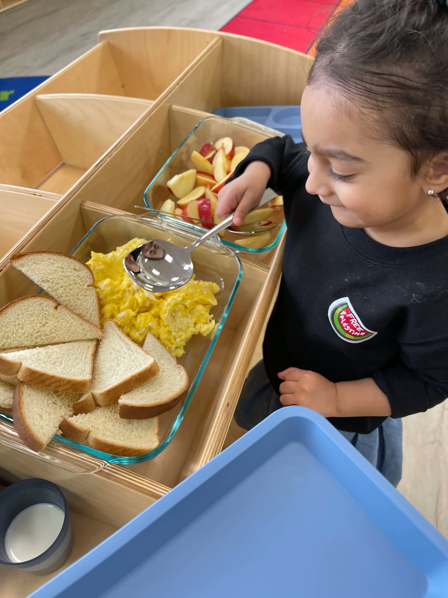 Child serving herself breakfast at a Little Muslims serving station