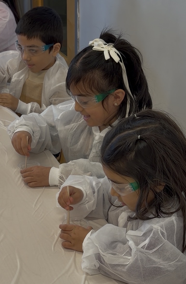 Children in lab coats doing a hands-on science experiment