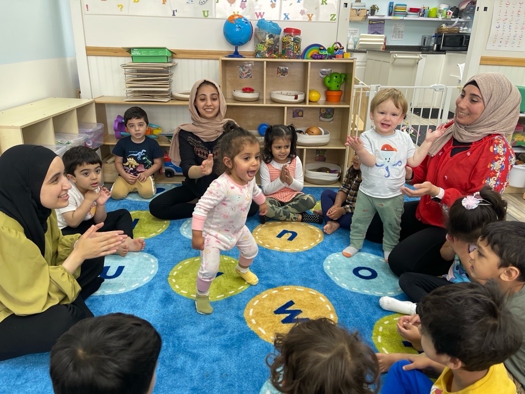 Teachers and children singing and clapping together
